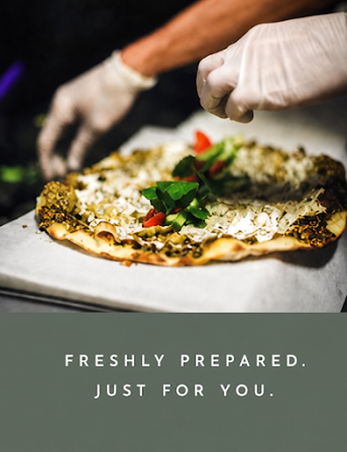 Préparation d'un manakish za'atar fraîchement sorti du four, photo légendée « Freshly prepared. Just for you. »