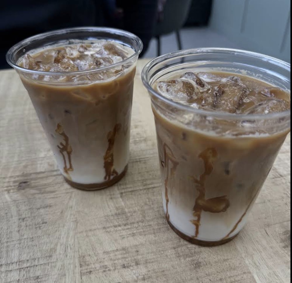 Deux cafés glacés servis sur une table en bois chez Labné